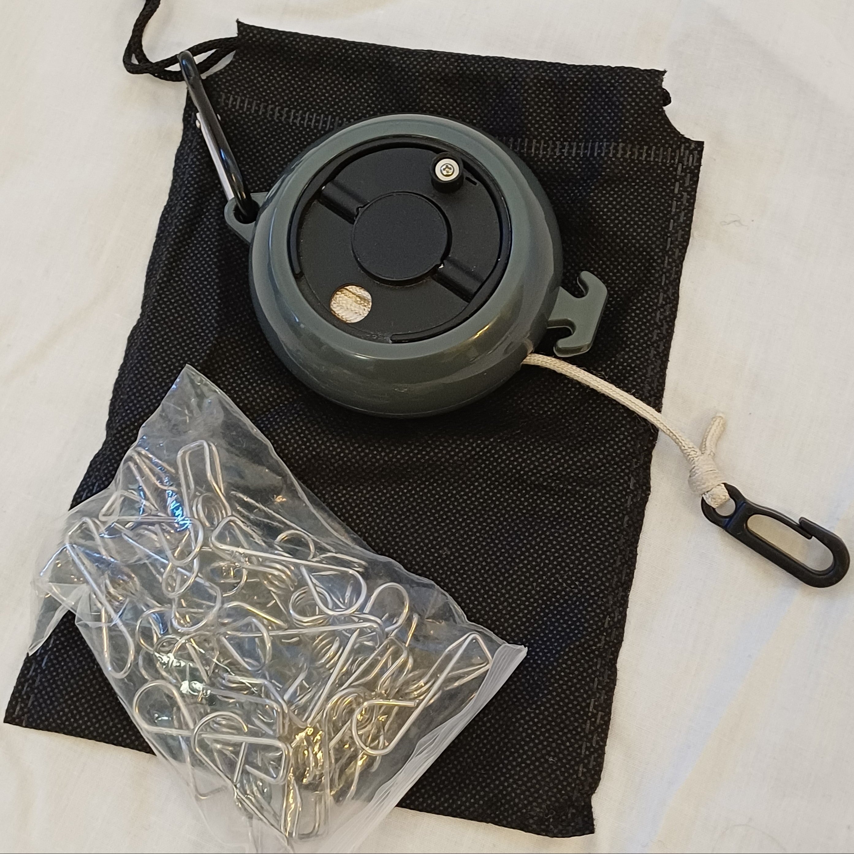 Black retractable clothes line on carry case with peg bag full of pegs