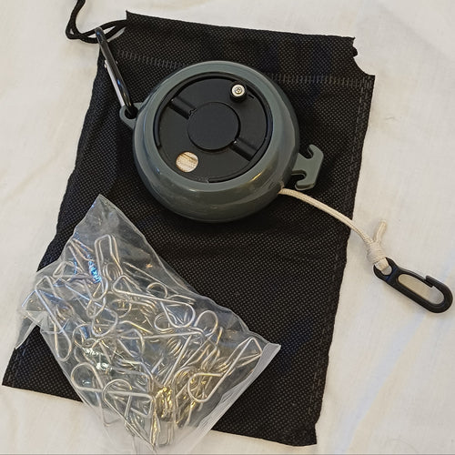 Black retractable clothes line on carry case with peg bag full of pegs