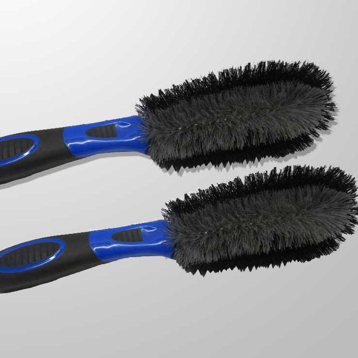 Two black and blue car cleaning brushes on a gray background