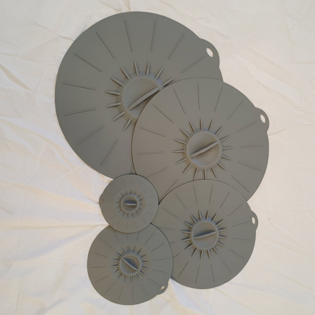 Silicon lids of various sizes on white background