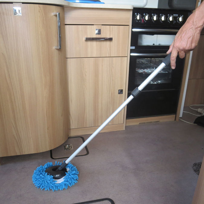 Microfiber cleaning brush with a long handle in a kitchen setting